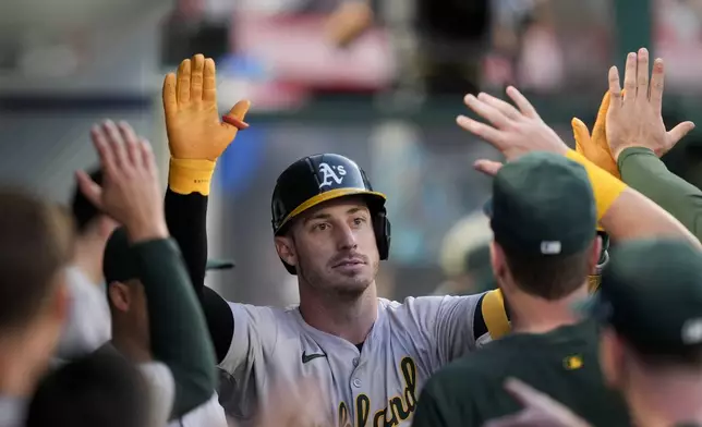 Oakland Athletics designated hitter Brent Rooker is congratulated for a solo home run against the Los Angeles Angels during the fifth inning of a baseball game Tuesday, June 25, 2024, in Anaheim, Calif. (AP Photo/Ryan Sun)