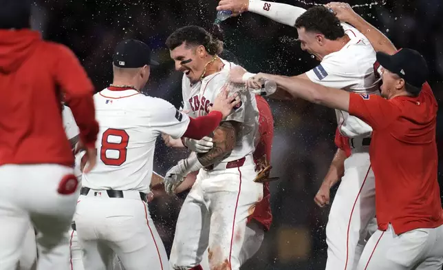 Boston Red Sox's Jarren Duran, center, is doused with water after his walk-off RBI single in the bottom of the ninth inning of a baseball game against the Toronto Blue Jays at Fenway Park, Monday, June 24, 2024, in Boston. (AP Photo/Charles Krupa)