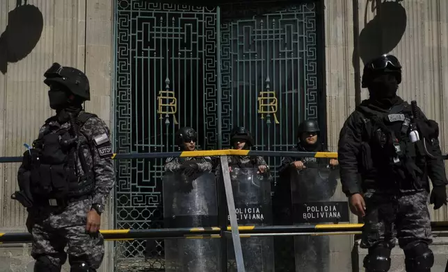 Police guard the government palace the day after an attempted government take-over in La Paz, Bolivia, Thursday, June 27, 2024. The government announced more arrests over their alleged involvement in what President Luis Arce called a coup attempt. (AP Photo/Carlos Sanchez)