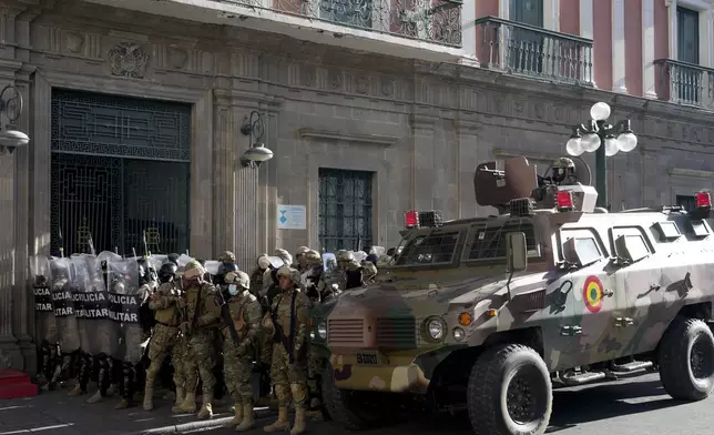 An armored vehicle and military police form outside the government palace at Plaza Murillo in La Paz, Bolivia, Wednesday, June 26, 2024. Armored vehicles rammed into the doors of Bolivia's government palace Wednesday as President Luis Arce said the country faced an attempted coup. (AP Photo/Juan Karita)