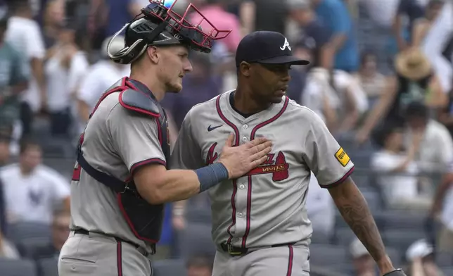 Atlanta Braves catcher Sean Murphy, left, and Raisel Iglesias, right, celebrate after defeating the New York Yankees in a baseball game, Sunday, June 23, 2024, in New York. (AP Photo/Pamela Smith)