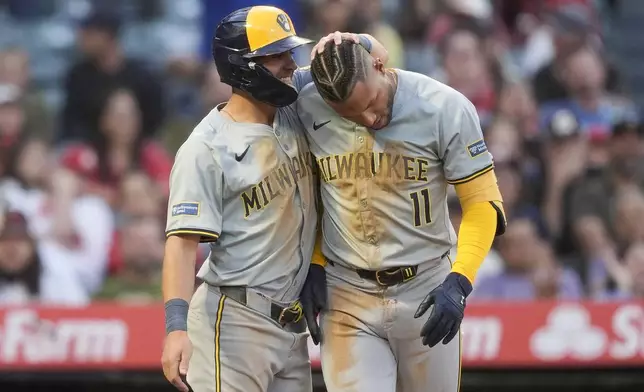 Milwaukee Brewers' Jackson Chourio (11) celebrates with Sal Frelick after scoring off a fielding error by Los Angeles Angels right fielder Jo Adell after hitting a double to score Frelick and Gary Sanchez during the fourth inning of a baseball game, Tuesday, June 18, 2024, in Anaheim, Calif. (AP Photo/Ryan Sun)