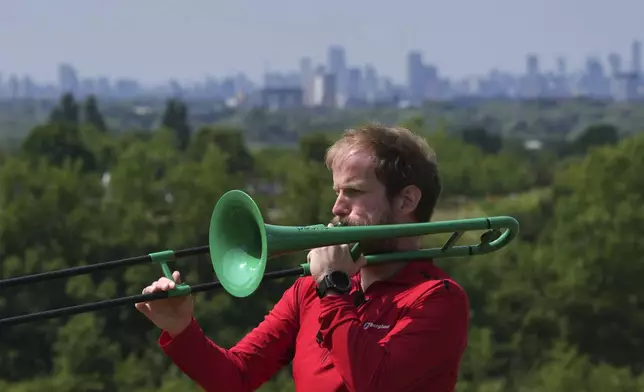 Nathaniel Dye plays trombone during an interview in London, Tuesday, June 18, 2024. Dismayed by delays in his cancer diagnosis by Britain’s National Health Service, Dye says he feels let down by the Conservative-led government, which health policy experts say has failed to adequately fund the NHS. As a result, he played a central role in the launch of Labour’s platform for the July 4 election. (AP Photo/Kin Cheung)