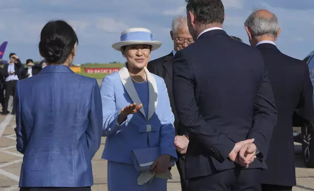 Empress Masako gestures as she speaks to dignitaries as she and Emperor Naruhito arrive at Stansted Airport, England, Saturday, June 22, 2024, ahead of a state visit. The state visit begins Tuesday, when King Charles III and Queen Camilla will formally welcome the Emperor and Empress before taking a ceremonial carriage ride to Buckingham Palace. (AP Photo/Kin Cheung)