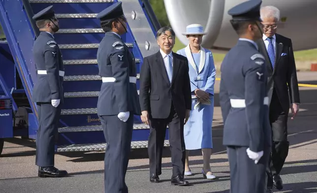 Emperor Naruhito and Empress Masako walk through a guard of honour after arriving at Stansted Airport, England, Saturday, June 22, 2024, ahead of a state visit. The state visit begins Tuesday, when King Charles III and Queen Camilla will formally welcome the Emperor and Empress before taking a ceremonial carriage ride to Buckingham Palace. (AP Photo/Kin Cheung)