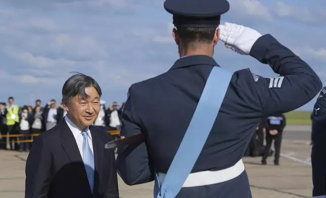 Emperor Naruhito is saluted by a member of the honour guard as he and Empress Masako arrive at Stansted Airport, England, Saturday, June 22, 2024, ahead of a state visit. The state visit begins Tuesday, when King Charles III and Queen Camilla will formally welcome the Emperor and Empress before taking a ceremonial carriage ride to Buckingham Palace. (AP Photo/Kin Cheung)