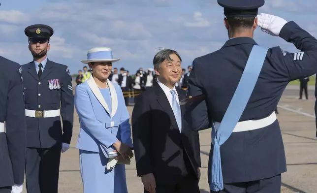 Emperor Naruhito is saluted by a member of the honour guard as he and Empress Masako arrive at Stansted Airport, England, Saturday, June 22, 2024, ahead of a state visit. The state visit begins Tuesday, when King Charles III and Queen Camilla will formally welcome the Emperor and Empress before taking a ceremonial carriage ride to Buckingham Palace. (AP Photo/Kin Cheung)