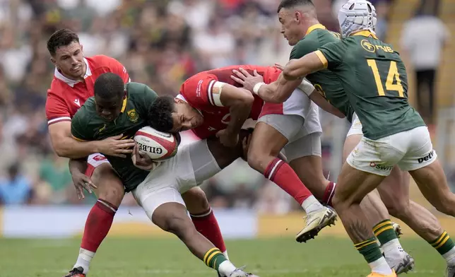 South Africa's Aphelele Fassi, center left, is tackled by Wales' Rio Dyer during the rugby union cup match between Wales and South Africa at Twickenham Stadium, London, Saturday June 22, 2024. (Andrew Matthews/PA via AP)