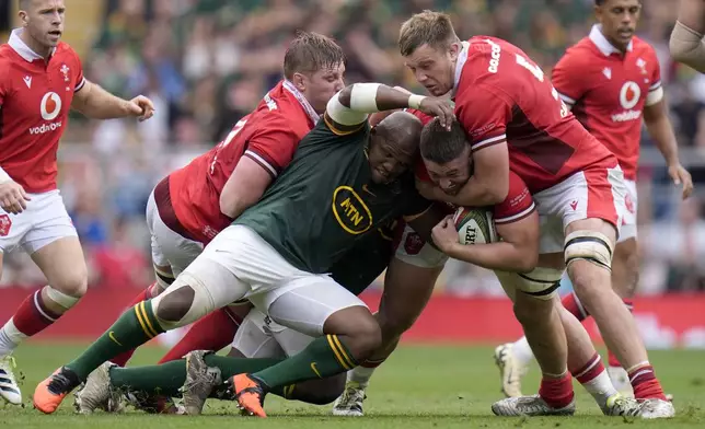 South Africa's Bongi Mbonambi, center left, tackles Wales' Gareth Thomas during the rugby union cup match between Wales and South Africa at Twickenham Stadium, London, Saturday June 22, 2024. (Andrew Matthews/PA via AP)