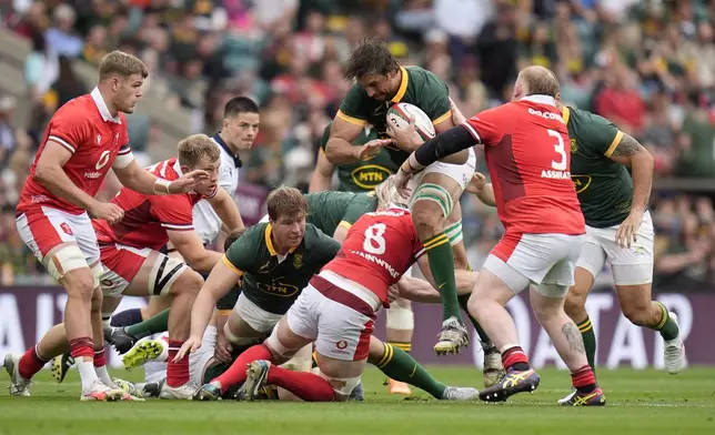 South Africa's Eben Etzebeth, centre, top, is tackled by Wales' Harri O'Connor, centre, bottom, and Owen Watkin, right, during the international rugby union match between South Africa and Wales, at Twickenham Stadium, London, Saturday June 22, 2024. (Andrew Matthews/PA via AP)