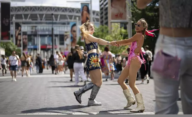 Taylor Swift fans pose for a picture outside Wembley Stadium before the first London concert of the Eras Tour on Friday, June 21, 2024 in London. (Photo by Scott A Garfitt/Invision/AP)