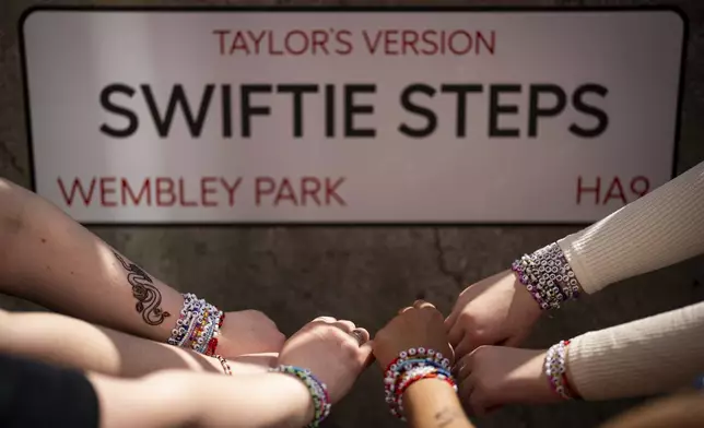 Taylor Swift fans pose with their bracelets infront of the "Swiftie Steps", commissioned by London Mayor Sadiq Khan, before the first London concert of the Eras Tour on Friday, June 21, 2024 in London. (Photo by Scott A Garfitt/Invision/AP)