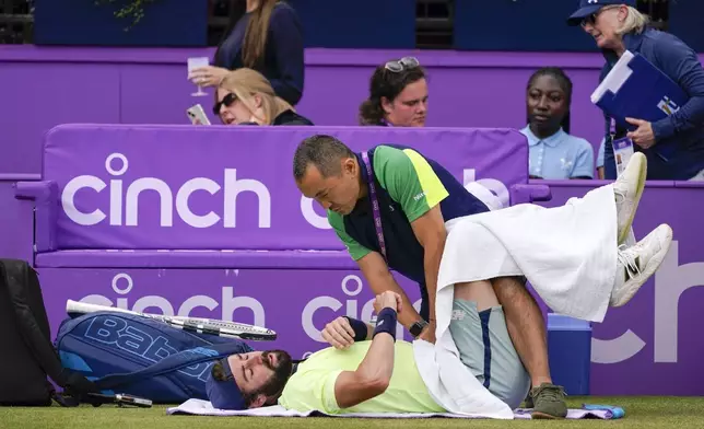 Jordan Thompson of Australia has a phisiotherapy session during his men's singles match on day eight of The Queen's Club tennis tournament, against Lorenzo Musetti of Italy in London, Saturday, June 22, 2024.(AP Photo/Alberto Pezzali)