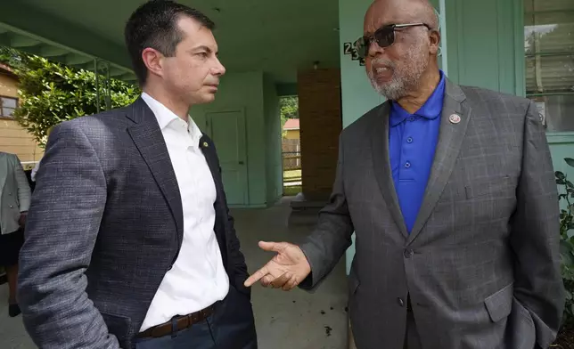 United States Transportation Secretary Pete Buttigieg, left, and U.S. Rep. Bennie Thompson, D-Miss., right, confer outside the house that is the Medgar and Myrlie Evers National Monument, Friday, June 21, 2024, in Jackson, Miss. The house was one of the stops Buttigieg made as he spent Thursday and Friday in Mississippi, promoting projects that will be helped or will be receiving money from a federal infrastructure act. (AP Photo/Rogelio V. Solis)