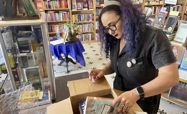 Becka Robbins, events manager and founder of the "Books Not Bans" program at Fabulosa Books, packs up LGBTQ+ books to be sent to parts of the country where they are censored on Thursday, June 27, 2024 at the Castro District of San Francisco. The bookstore is sending LGBTQ+ books to where they are censored to counter the rapidly growing effort by anti-LGBTQ+ activists and lawmakers to ban queer-friendly books from public schools and libraries. (AP Photo/Haven Daley)