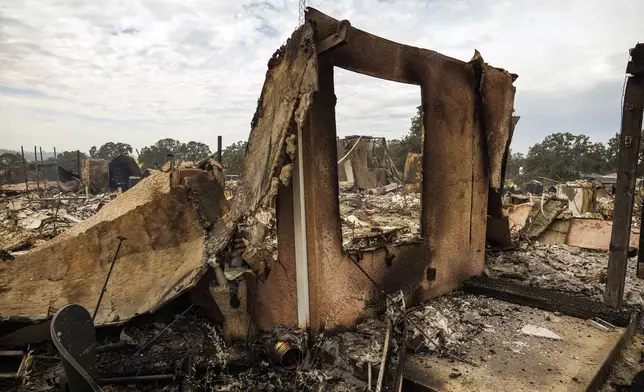 The remains of a structure destroyed by the Apache Fire as it burns in Palermo, Calif., on Tuesday, Jun. 25, 2024. According to Cal Fire, more than a dozen new fires sparked by lightning. (AP Photo/Ethan Swope)