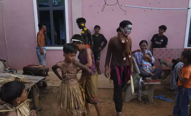 Young boys dress up to participate in the He Neak Ta rituals in Phum Boeung village, northwest of Phnom Penh, Cambodia, Tuesday, June 11, 2024. Cambodian villagers on Tuesday took part in a rare traditional guardian spirit ceremony praying for good fortune, rain and prosperity, as they aimed to preserve this ancient tradition. (AP Photo/Heng Sinith)