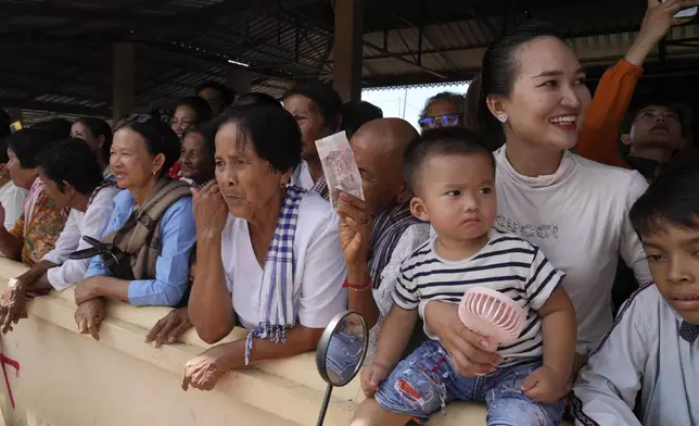 Villagers watch the He Neak Ta rituals in Phum Boeung village, northwest of Phnom Penh, Cambodia, Tuesday, June 11, 2024. Cambodian villagers on Tuesday took part in a rare traditional guardian spirit ceremony praying for good fortune, rain and prosperity, as they aimed to preserve this ancient tradition. (AP Photo/Heng Sinith)