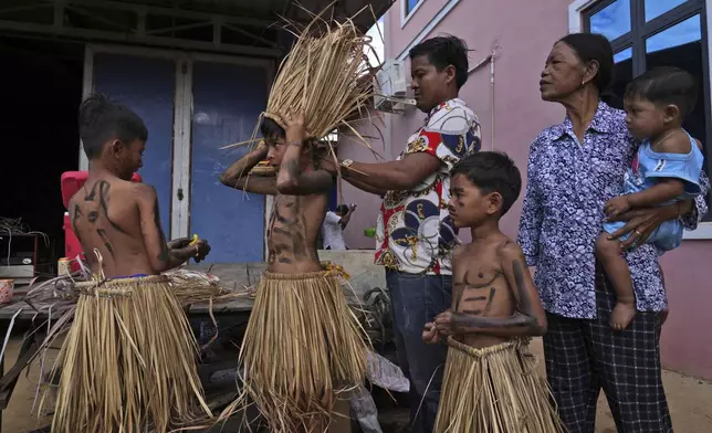 Young boys dress up to participate in the He Neak Ta rituals in Phum Boeung village, northwest of Phnom Penh, Cambodia, Tuesday, June 11, 2024. Cambodian villagers on Tuesday took part in a rare traditional guardian spirit ceremony praying for good fortune, rain and prosperity, as they aimed to preserve this ancient tradition. (AP Photo/Heng Sinith)