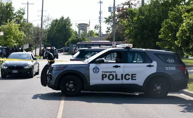 Toronto police officers respond to a deadly shooting in north Toronto, Monday, June 17, 2024. (Arlyn McAdorey/The Canadian Press via AP)