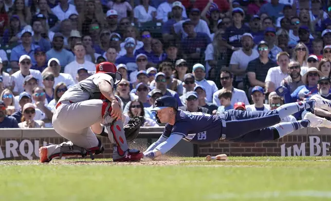 Chicago Cubs' Pete Crow-Armstrong, right, is tagged out at home plate by St. Louis Cardinals catcher Pedro Pagés, left, during the eighth inning of a baseball game Friday, June 14, 2024, in Chicago. (AP Photo/David Banks)