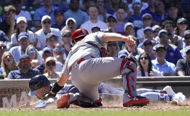 Chicago Cubs Pete Crow-Armstrong, left, is tagged out at home plate by St. Louis Cardinals catcher Pedro Pagés, right, during the eighth inning of a baseball game Friday, June 14, 2024, in Chicago. (AP Photo/David Banks)