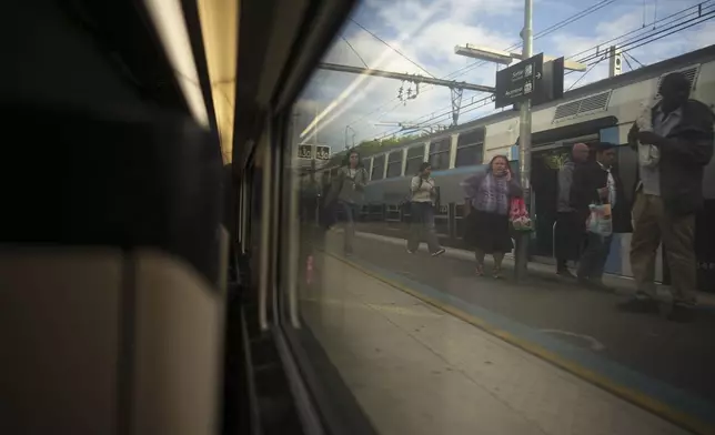 Passengers are visible through a window of a high-speed train in Paris, France, Monday, May 27, 2024. (AP Photo/Daniel Cole)