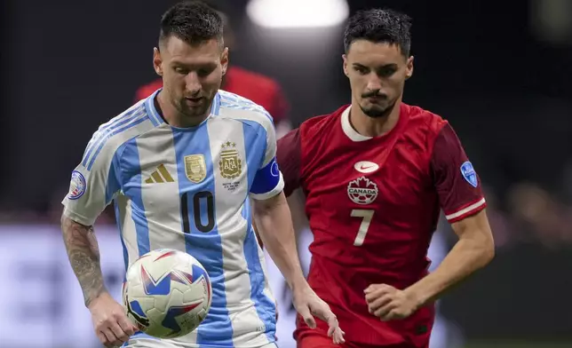 Argentina's Lionel Messi, left, and Canada's Stephen Eustaquio battle for the ball during a Copa America Group A soccer match in Atlanta, Thursday, June 20, 2024. (AP Photo/Jason Allen)
