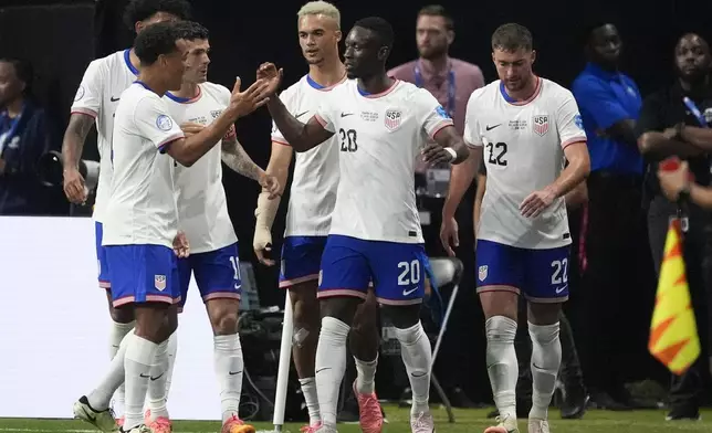 Folarin Balogun of the United States (20), celebrates with teammates after scoring his side's opening goal against Panama during a Copa America Group C soccer match in Atlanta, Thursday, June 27, 2024. (AP Photo/Mike Stewart)