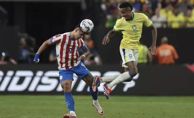 Paraguay's Adam Bareiro heads the ball challenged by Brazil's Eder Militao during a Copa America Group D soccer match in Las Vegas, Friday, June 28, 2024. (AP Photo/L.E. Baskow)