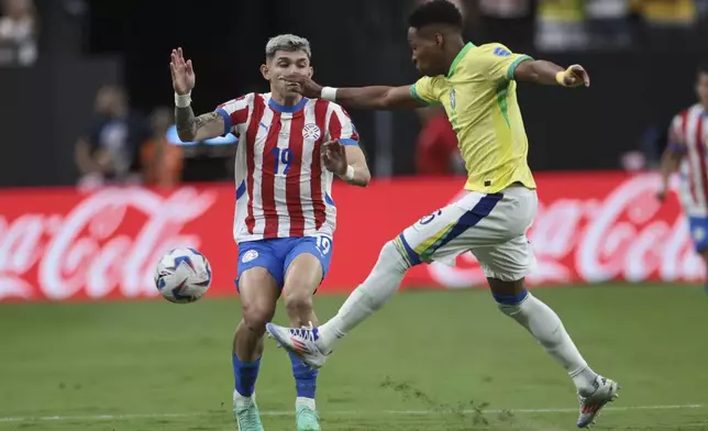 Brazil's Wendell, right, clears the ball away from Paraguay's Julio Enciso during a Copa America Group D soccer match in Las Vegas, Friday, June 28, 2024. (AP Photo/L.E. Baskow)