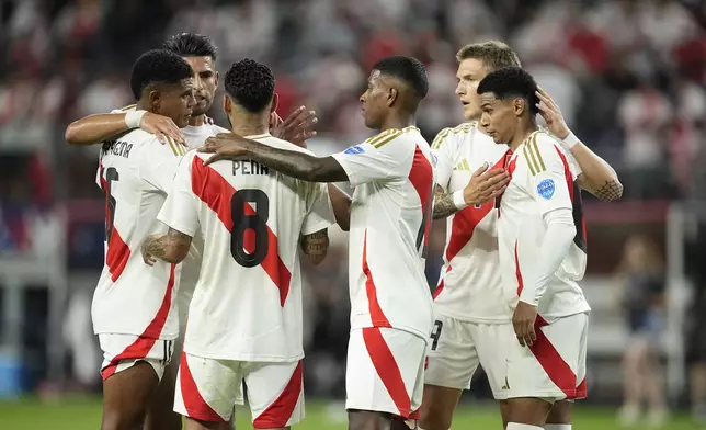 Peru players embrace at the end of a Copa America Group A soccer match against Chile in Arlington, Texas, Friday, June 21, 2024. (AP Photo/Tony Gutierrez)