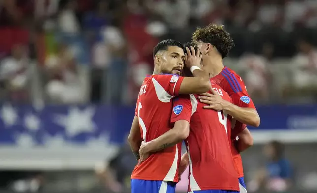 Chile players embrace at the end of a Copa America Group A soccer match against Peru in Arlington, Texas, Friday, June 21, 2024. (AP Photo/Julio Cortez)