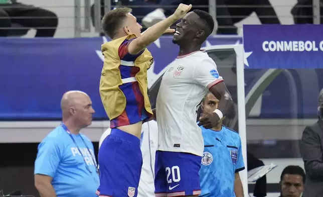 Folarin Balogun of the United States, right, celebrates with teammate Kristoffer Lund after scoring his side's 2nd goal against Bolivia during a Copa America Group C soccer match in Arlington, Texas, Sunday, June 23, 2024. (AP Photo/Julio Cortez)