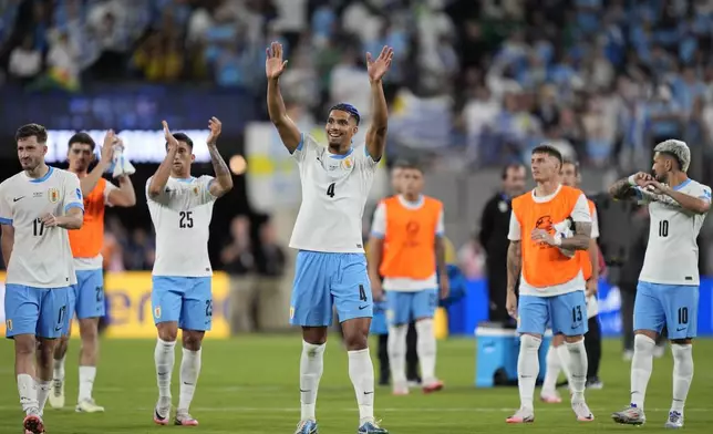 Uruguay's Ronald Araujo, center, and teammates celebrate their team's 5-0 victory over Bolivia at the end of a Copa America Group C soccer match in East Rutherford, N.J., Thursday, June 27, 2024. (AP Photo/Julia Nikhinson)