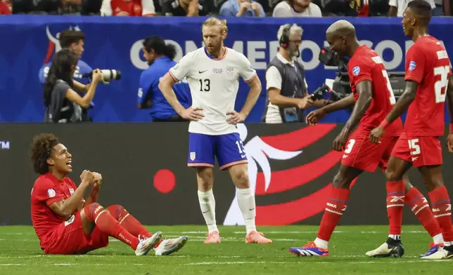 Panama players celebrate as U.S. defender Tim Ream (13) watches after Panama's win during a Copa América 2024 Group C soccer match Thursday, June 27, 2024, in Atlanta. (Miguel Martinez//Atlanta Journal-Constitution via AP)