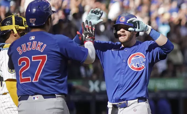Chicago Cubs' Ian Happ, right, is congratulated by Seiya Suzuki (27) after hitting a two-run home run during the eighth inning of a baseball game against the Milwaukee Brewers, Saturday, June 29, 2024, in Milwaukee. (AP Photo/Aaron Gash)