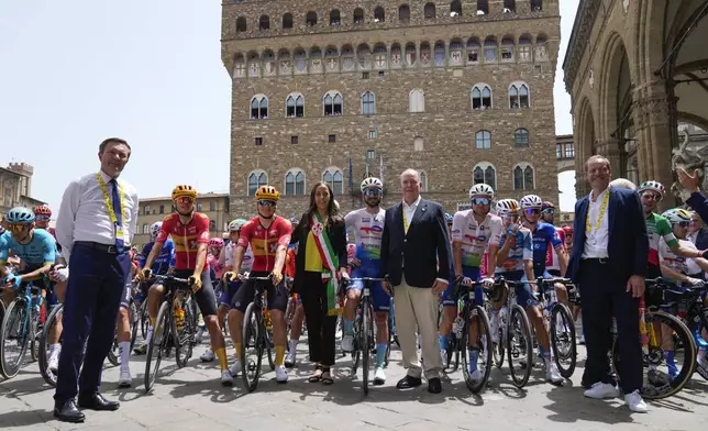 Monaco's Prince Albert, center, Sara Funaro, mayor of Florence, center left, and Tour director Christian Prudhomme, right, pose during the official opening ceremony during the first stage of the Tour de France cycling race over 206 kilometers (128 miles) with start in Florence and finish in Rimini, Italy, Saturday, June 29, 2024. (AP Photo/Jerome Delay)