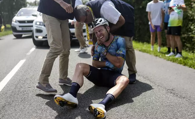 FILE - Britain's Mark Cavendish grimaces in pain as he receives medical assistance after crashing during the eighth stage of the Tour de France cycling race over 201 kilometers (125 miles) with start in Libourne and finish in Limoges, France, Saturday, July 8, 2023. (AP Photo/Thibault Camus, File)