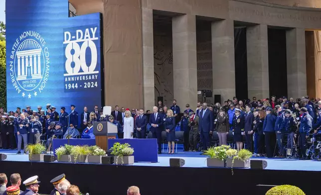 U.S. President Joe Biden, center second right, first lady Jill Biden, center right, French President Emmanuel Macron, center second left, and his wife Brigitte Macron, center left, and American WWII veterans attend a ceremony to mark the 80th anniversary of D-Day at the Normandy American Cemetery in Colleville-sur-Mer, Normandy, France, Thursday, June 6, 2024. World leaders are gathered Thursday in France to mark the 80th anniversary of the D-Day landings. (AP Photo/Virginia Mayo)