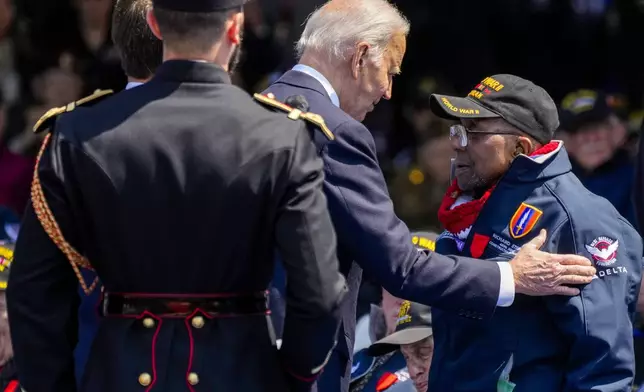 President Joe Biden greets World War II veteran Richard Stewart after he was awarded in the Legion of Honor by French President Emmanuel Macron during a ceremony to mark the 80th anniversary of D-Day at the Normandy American Cemetery in Colleville-sur-Mer, Normandy, France, Thursday, June 6, 2024. World leaders are gathered Thursday in France to mark the 80th anniversary of the D-Day landings. (AP Photo/Virginia Mayo)