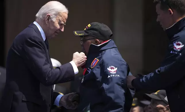 President Joe Biden greets WW II veteran Richard Stewart after he was awarded in the Legion of Honor by French President Emmanuel Macron, during a commemorative ceremony to mark D-Day 80th anniversary, Thursday, June 6, 2024 at the US cemetery in Colleville-sur-Mer, Normandy. Normandy is hosting various events to officially commemorate the 80th anniversary of the D-Day landings that took place on June 6, 1944. (AP Photo/Daniel Cole, Pool)