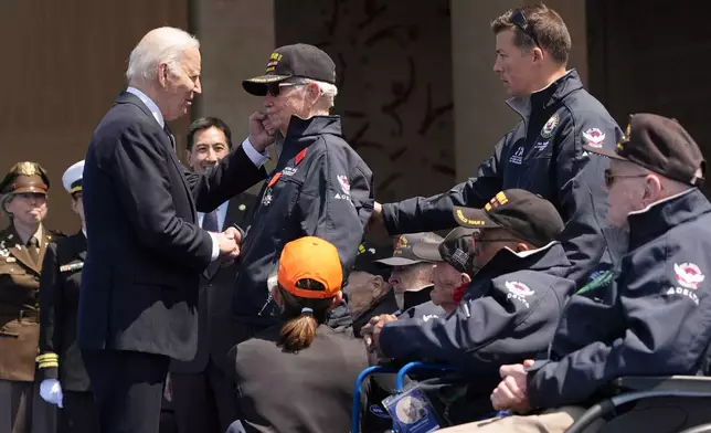 President Joe Biden speaks with War II veteran Victor Charey after French President Emmanuel Macron honored Carey with the Legion of Honor medal, during a ceremony to mark the 80th anniversary of D-Day, Thursday, June 6, 2024, in Normandy. (AP Photo/Evan Vucci)