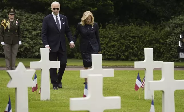 President Joe Biden and first lady Jill Biden walk in the Normandy American Cemetery following a ceremony to mark the 80th anniversary of D-Day, Thursday, June 6, 2024, in Normandy. (AP Photo/Evan Vucci)