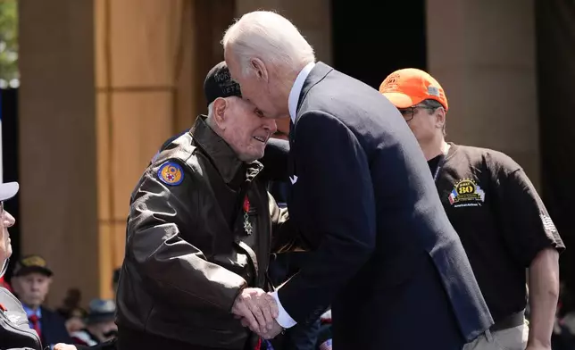 President Joe Biden speaks with World War II veteran Bob Pedigo after French President Emmanuel Macron honored Pedigo with the Legion of Honor medal, during a ceremony to mark the 80th anniversary of D-Day, Thursday, June 6, 2024, in Normandy. (AP Photo/Evan Vucci)