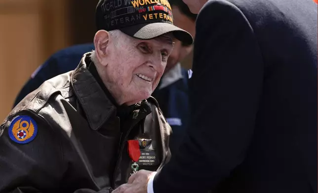 President Joe Biden speaks with World War II veteran Bob Pedigo after French President Emmanuel Macron honored Pedigo with the Legion of Honor medal, during a ceremony to mark the 80th anniversary of D-Day, Thursday, June 6, 2024, in Normandy. (AP Photo/Evan Vucci)