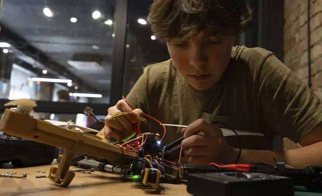 Misha Soboliev, 17, works on drone details in his school, in Kyiv, Ukraine, on May 1, 2024. He built a drone to send to his father's army unit. (AP Photo/Alex Babenko)