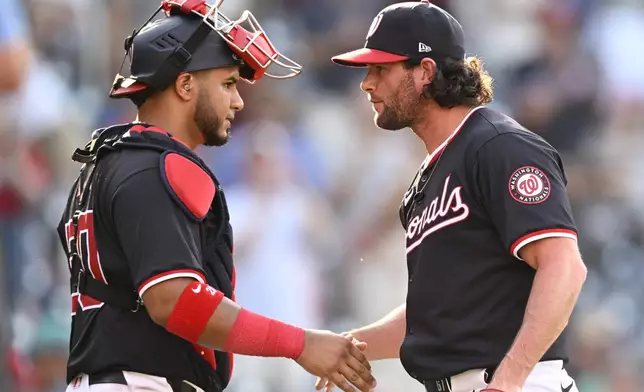 Washington Nationals catcher Keibert Ruiz, left, shakes hands with closing pitcher Kyle Finnegan after the team's baseball game against the Atlanta Braves on Wednesday, June 19, 2024, in Washington. (AP Photo/John McDonnell)