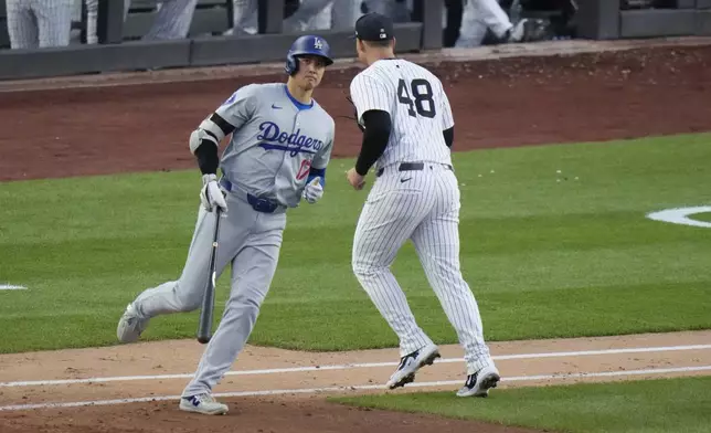 Los Angeles Dodgers' Shohei Ohtani passes New York Yankees' Anthony Rizzo (48) after flying out during the third inning of a baseball game Friday, June 7, 2024, in New York. (AP Photo/Frank Franklin II)