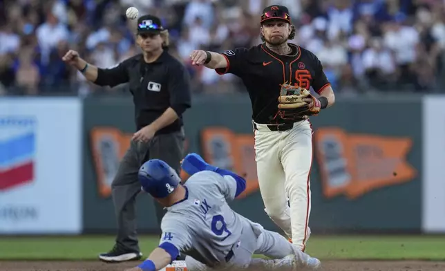 San Francisco Giants second baseman Brett Wisely, right, turns a double play after forcing out Los Angeles Dodgers' Gavin Lux at second during the eighth inning of a baseball game Saturday, June 29, 2024, in San Francisco. Kiké Hernández was out at first. (AP Photo/Godofredo A. Vásquez)